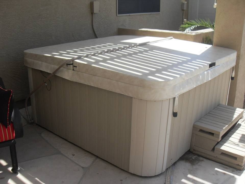 Custom fitted spa cover installed on a backyard hot tub