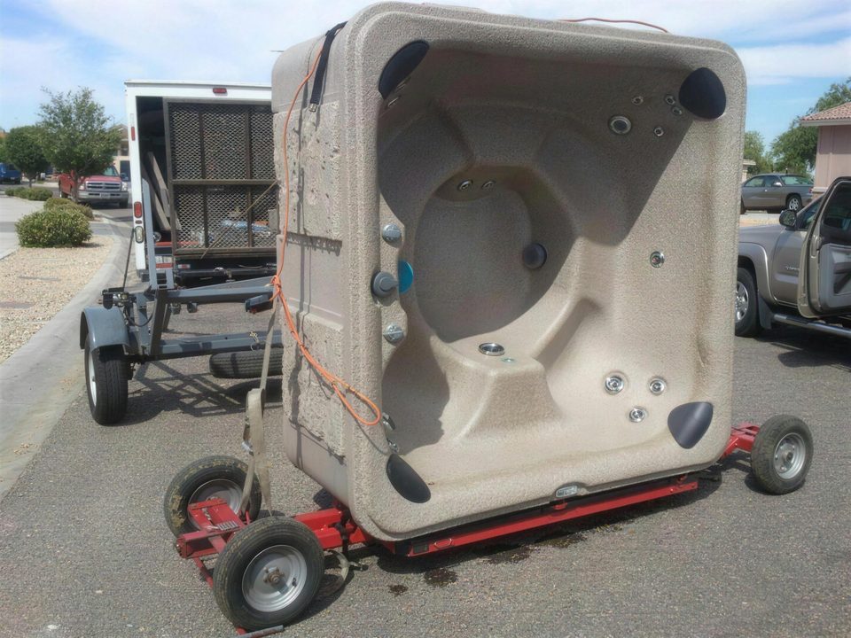 Hot tub loaded on the red rolling dolly in a customer driveway