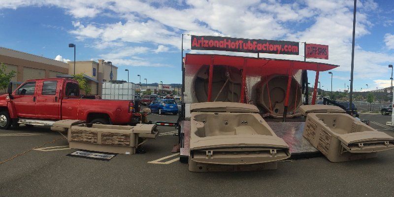 Red moving truck loaded with hot tub shells