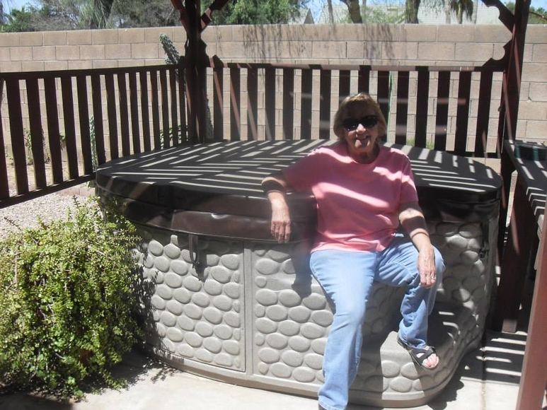 Customer seated on the edge of her delivered hot tub